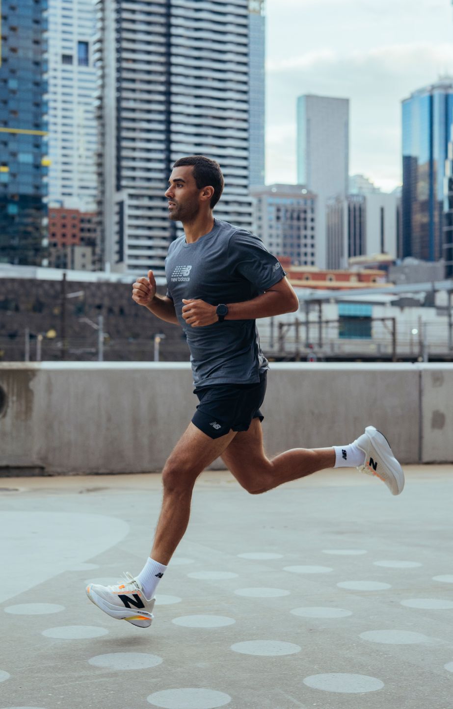 man running on a footpath, wearing new balance fuelcell supercomp trainer v3 shoes